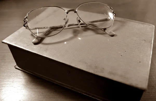 Glasses on the old book sepia — Stock Photo, Image