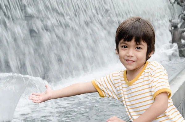 Malý chlapec hrát vodní fontána — Stock fotografie