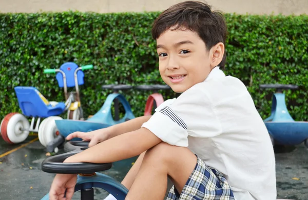 Niño jugando mini coche triciclo — Foto de Stock