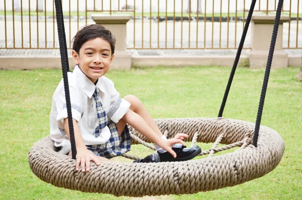 Estudante menino jogar swing na escola — Fotografia de Stock