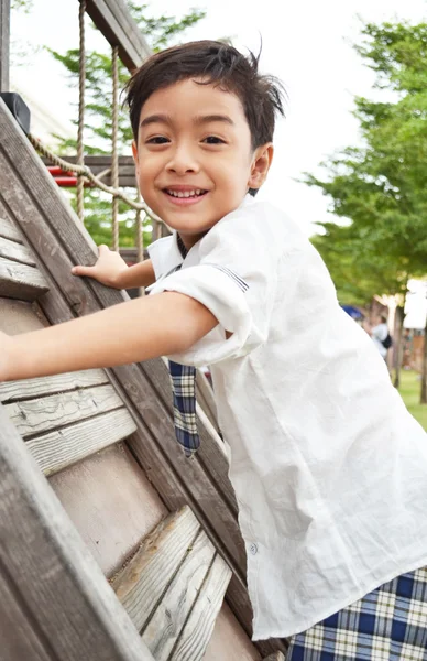 Rapaz estudante sobe ao parque infantil — Fotografia de Stock