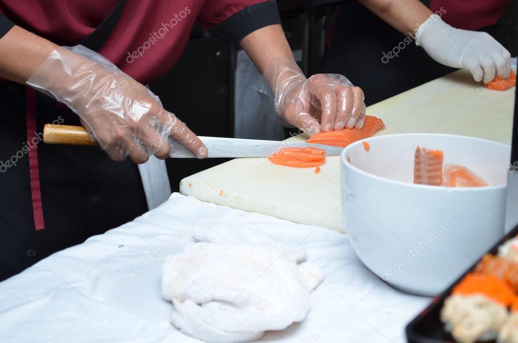 Japanese chef slicing salmon sushi