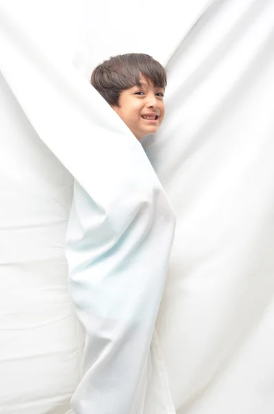 Little boy inside white fabric smiling — Stock Photo, Image