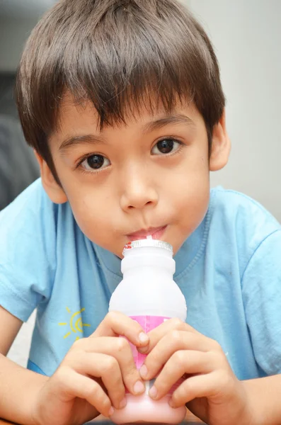 Menino bebendo leite morango favor — Fotografia de Stock