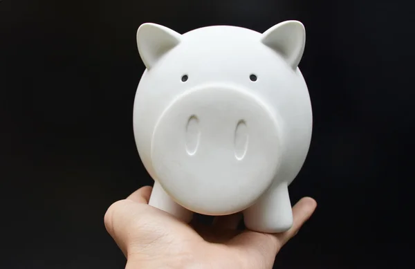 Piggy bank on woman hand black background — Stock Photo, Image