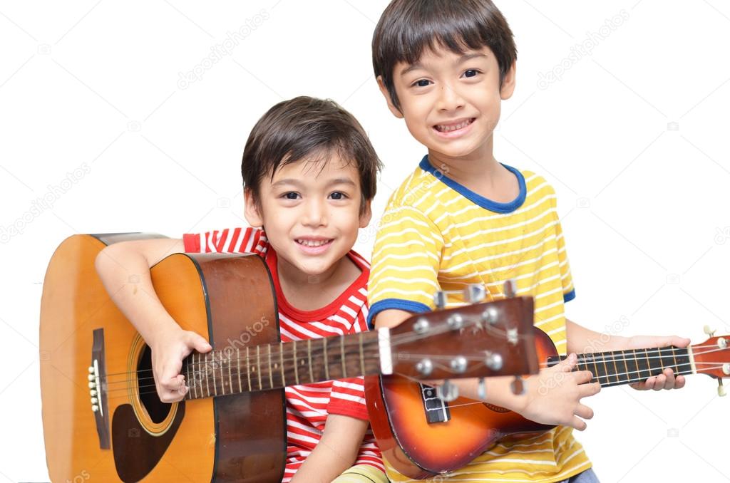 little sibling boy playing guitar and ukulele happy face