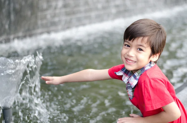 小男孩接触水喷泉 — 图库照片