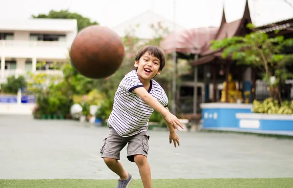 Menino jogando bola no playground — Fotografia de Stock