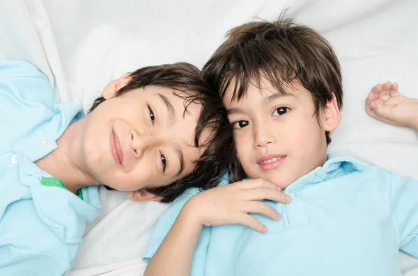 Kleine broer of zus jongen vaststelling van op het bed — Stockfoto