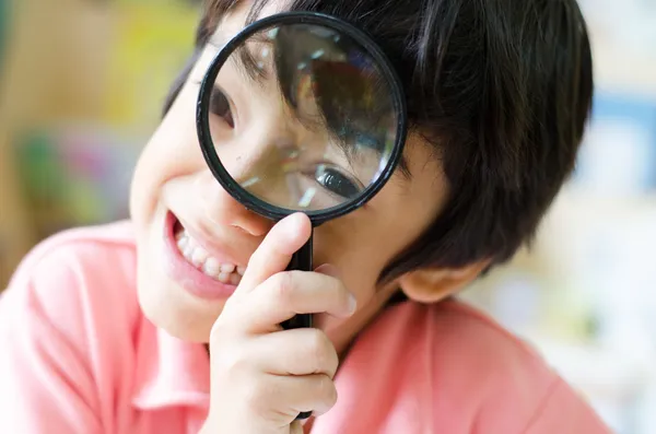 Little boy with magnifier on eyes close up — Stock Photo, Image