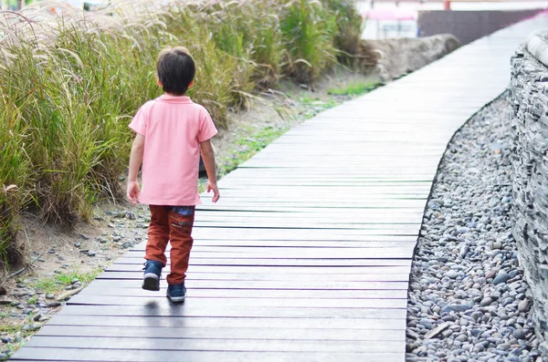 Niño pequeño caminando en el puente de madera — Foto de Stock