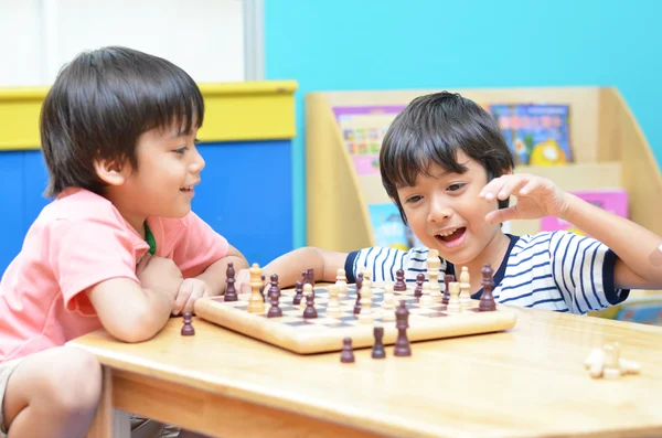Petit garçon siblibg jouant aux échecs — Photo