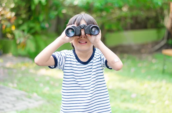 Petit garçon regardant à travers une jumelle — Photo