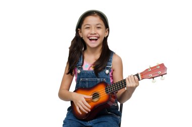Ukulele beyaz arka plan üzerinde oynarken küçük kız