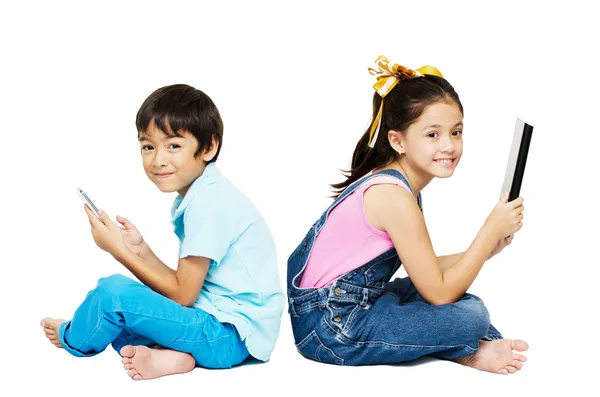 Menino e menina jogando telefone e tablet no fundo branco — Fotografia de Stock