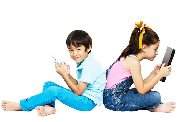 Menino e menina jogando telefone e tablet no fundo branco — Fotografia de Stock