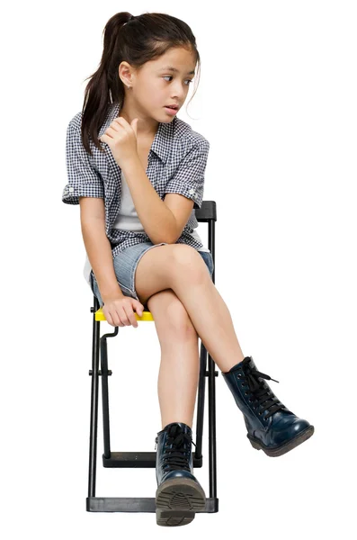 Menina sentada na cadeira retrato no fundo branco — Fotografia de Stock