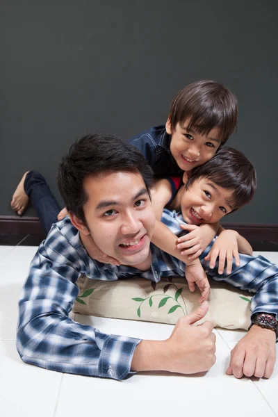 Father and sons laying together happy face — Stock Photo, Image