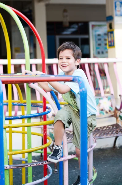 Lilla pojke klättring på lekplats — Stockfoto