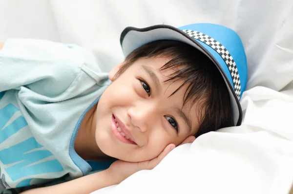 Niño tendido en el sofá mirando a la cámara — Foto de Stock