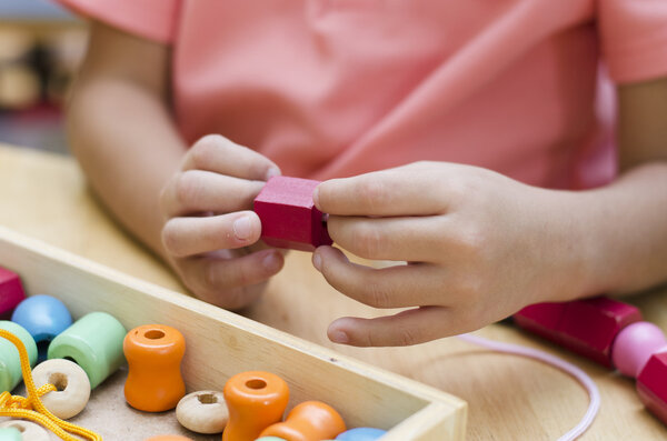 Little boy with Montessori material colored beads 