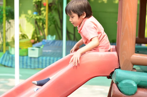 Pequeño niño deslizante tiempo de juego al aire libre — Foto de Stock