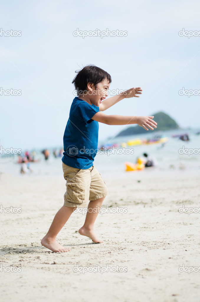 Little boy running to the ocean on the beach