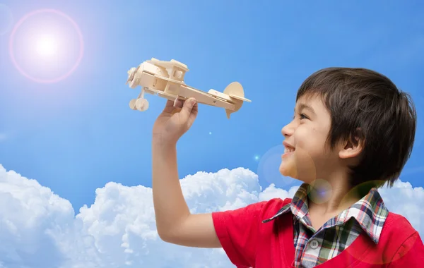 Küçük çocuk uçak ahşap oyuncak mavi gökyüzü ile oynama — Stok fotoğraf