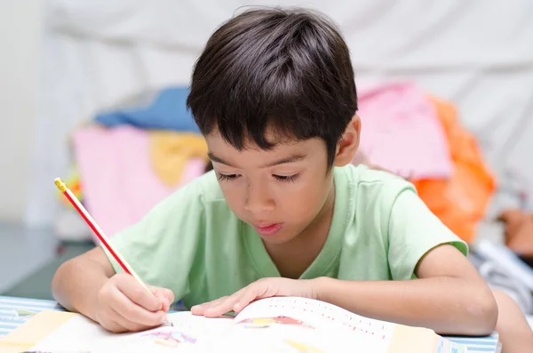 Kleiner Junge schreibt Hausaufgaben — Stockfoto