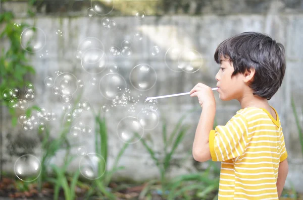 Petit garçon soufflant bulles de savon — Photo