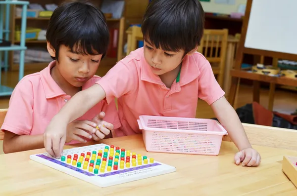 Kleine Jungen studieren Farbe der Stecknadel aus Montessori-Bildungs-ma — Stockfoto