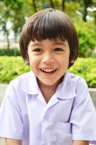 Weinig schattige jongen glimlachend in de tuin — Stockfoto