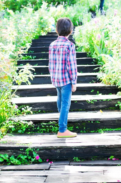 Мальчик идет по лестнице, поднимаясь в гору. — стоковое фото