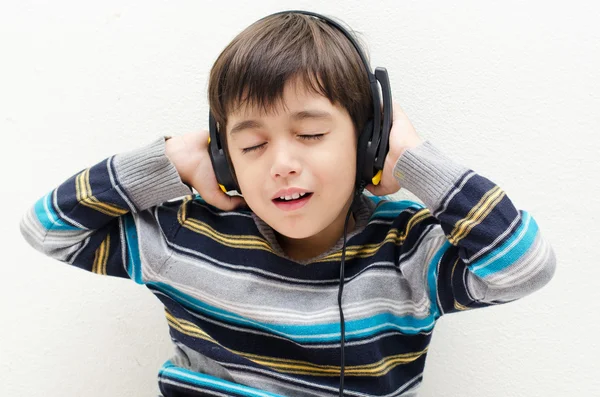 Menino ouvindo a música com fone de ouvido — Fotografia de Stock