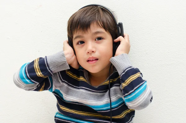 Menino ouvindo a música com fone de ouvido — Fotografia de Stock