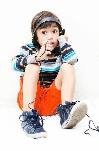 Liten pojke lyssna på musik med headsetet — Stockfoto
