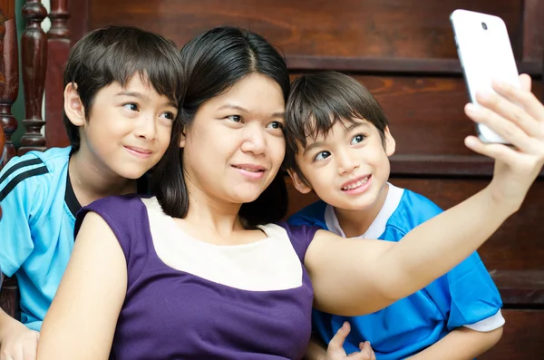 Mother and sons taking selfie with mobile in house — Stock Photo, Image