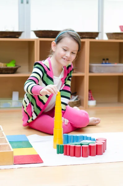 Little girl hand building tower made of montessori educational m — Stock Photo, Image
