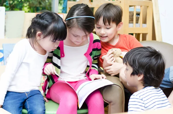 Porträtt av vänlig grupp läsa bok i klassrummet — Stockfoto