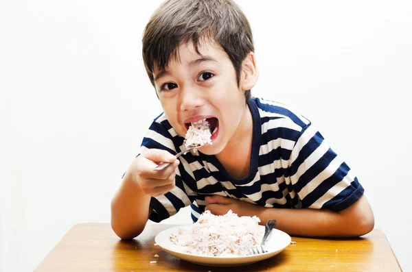 Маленький мальчик ест рис счастливое лицо — стоковое фото