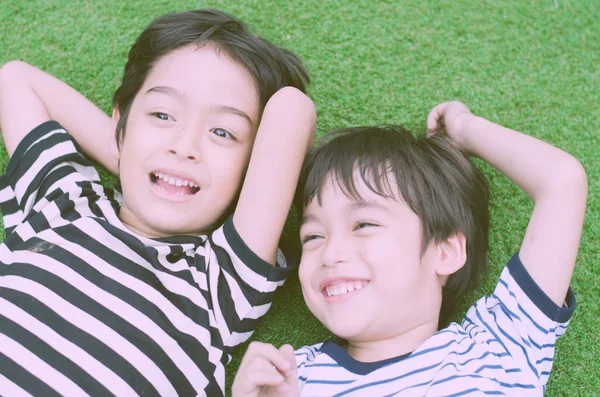 Kleine broer of zus jongen vast op gras vitage stijl — Stockfoto