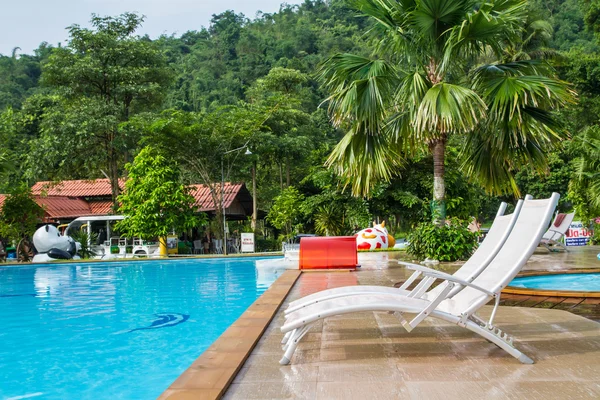 White lounges next to a swimming pool — Stock Photo, Image