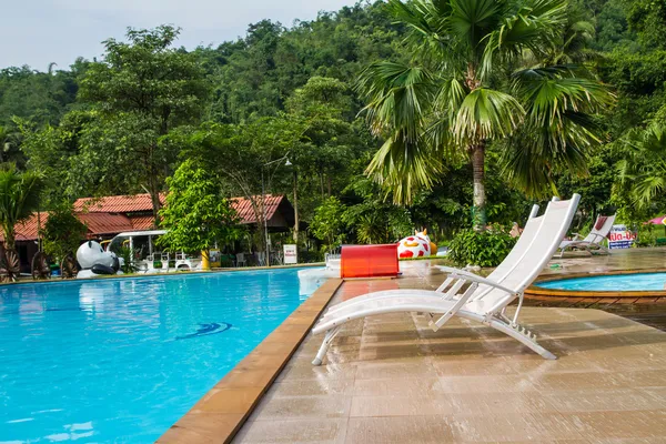 Cadeiras de praia brancas no deck da piscina — Fotografia de Stock