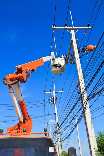 Eletricista reparar linha de energia e céu azul no fundo — Fotografia de Stock