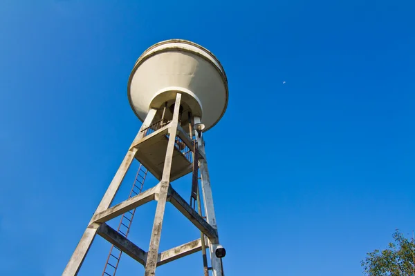 Tanque de abastecimento de água com céu azul e lua no fundo — Fotografia de Stock