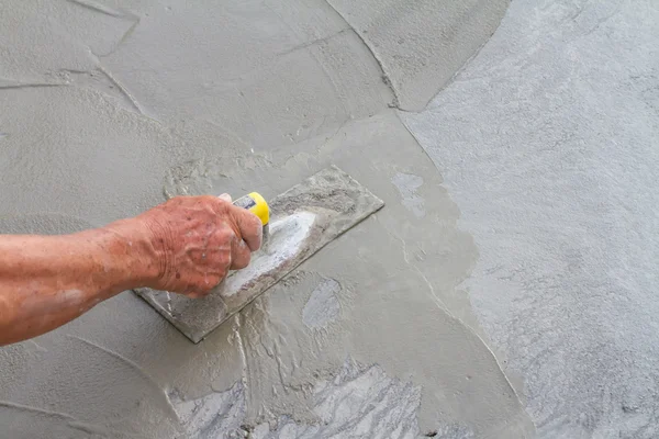 Tangan menggunakan sekop pada beton segar — Stok Foto