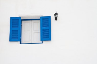 Beyaz duvardaki mavi pencere