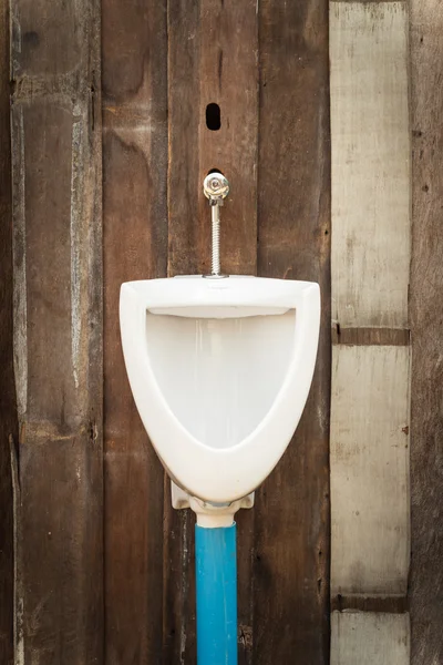 Antiguo urinario en pared de madera —  Fotos de Stock