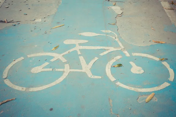 Bicicleta sinal caminho na estrada velha rachada — Fotografia de Stock