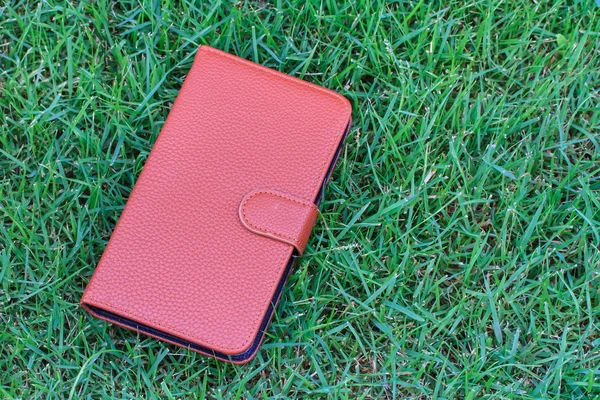 Capa de caixa de couro Smartphone no fundo de grama verde — Fotografia de Stock